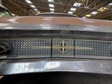 a close up of the front of an old car in a garage