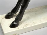 statue of a horse on a white base with a black mane