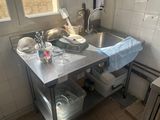 a kitchen with a sink and a counter with dishes and utensils on it