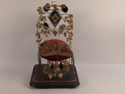 une petite chaise décorative sur laquelle est posé un coussin rouge