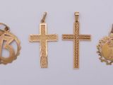 trois croix en or et un pendentif en forme de croix sur fond blanc