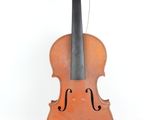 un vieux violon posé sur une surface blanche, près d'un mur blanc