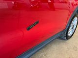 a close up of a red car with a sticker on it