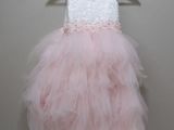 une robe rose et blanche suspendue à un cintre contre un mur