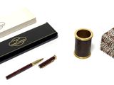 un stylo, une boîte et un pot à crayons posés sur une table