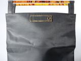 sac en cuir noir muni d'une poignée et d'une poignée en bois sur fond blanc
