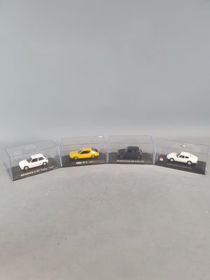 three toy cars are in a display case on a table