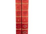 two red books sitting on top of each other on a white surface