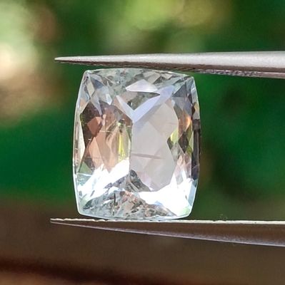 a clear crystal stone being held by a pair of pliers