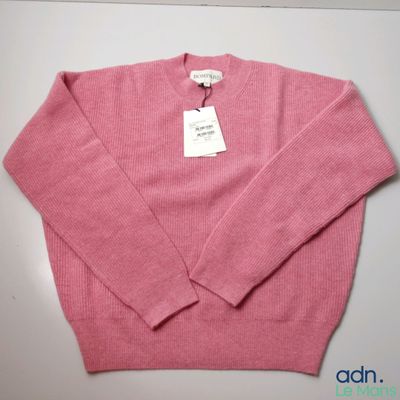 the sweater is pink and has a white tag on it