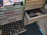 a drawer full of assorted items in a green cabinet