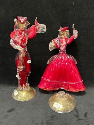 deux figurines représentant un homme et une femme vêtus de rouge