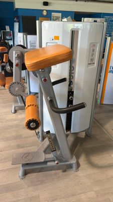 several machines in a gym with a refrigerator in the background