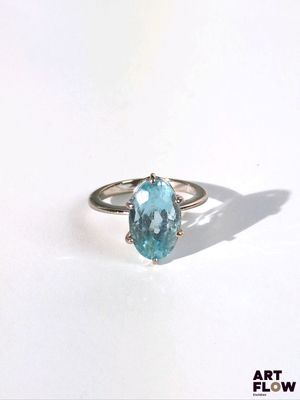 une image d'une bague avec une pierre en topaze bleue