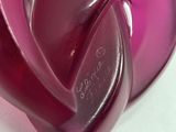 a purple glass heart shaped object on a white surface