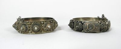 Deux bracelets rigides en métal argenté à décor de cabochons…