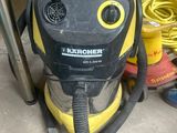 un aspirateur jaune et noir posé par terre