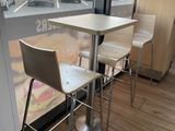 tables and chairs in front of a window with a view of a parking lot