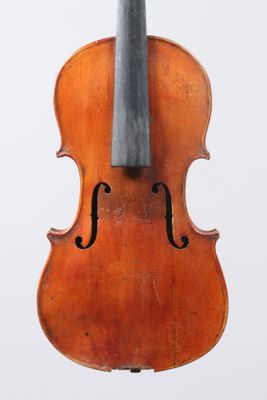an old violin sitting on top of a white surface