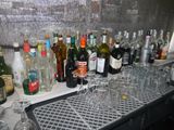 many bottles and glasses sitting on the bar counter