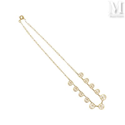 un collier plaqué or orné d'un motif floral sur fond blanc