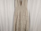 the dress is hanging on a hanger in front of a white curtain