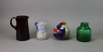 trois vases et une cruche sont posés sur une surface blanche