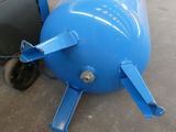 a large blue tank sitting on the floor next to a truck