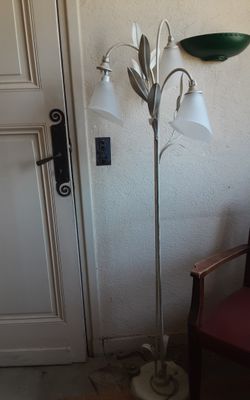 une lampe qui se trouve à côté d'une chaise dans une pièce