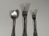 three forks and spoons are sitting on a table