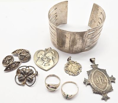 bracelets, bagues et autres bijoux en argent posés sur un fond blanc