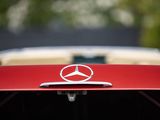 the front end of a red car with a mercedes emblem on it