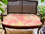 a wooden bench with a red cushion on it in front of a window