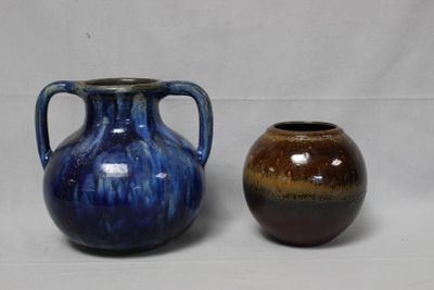 deux vases posés l'un à côté de l'autre sur une surface blanche