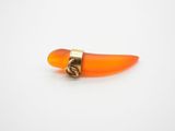 un gros plan d'un petit objet orange posé sur une surface blanche