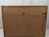 a cardboard box sitting on a white surface with a white curtain behind it