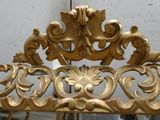 a mirror that has a gold frame on it