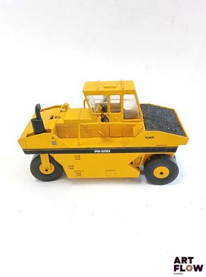 un petit camion jaune posé sur une surface blanche
