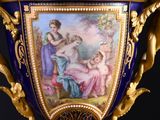 a blue and gold vase with a painting on it