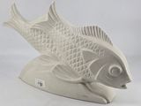 a white sculpture of a fish on a white surface