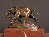 bronze statue of an elephant on a marble base on a table