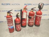 fire extinguisors are lined up in a row on a table