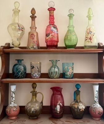 many different colored vases on a shelf in a room