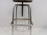 une image représentant un tabouret en métal avec une assise en bois, sur fond blanc