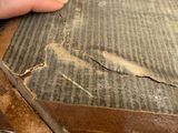 a person that is holding a piece of cardboard on a table