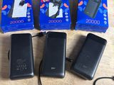 three black cell phones sitting on top of a table next to each other