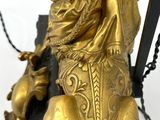 a gold statue of a lion on a black base