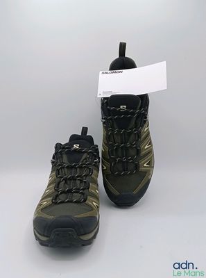 la paire de chaussures de randonnée est posée côte à côte sur une surface blanche