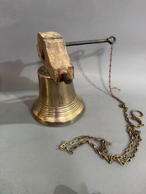 une cloche attachée à une chaîne, posée sur une table