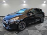 une voiture noire est garée dans une pièce au sol en damier
